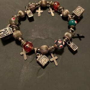 Stretch silver tone Charm Bracelet. Lots of pretty charms. Good condition.